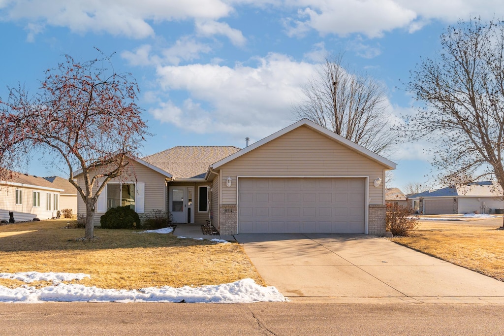 ranch-style house with a garage, driveway, and brick siding