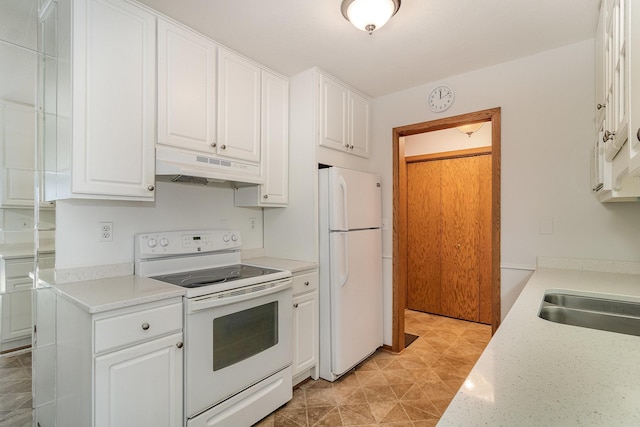 kitchen with white appliances, light stone counters, white cabinetry, and sink