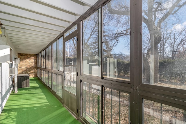 unfurnished sunroom featuring beam ceiling and a healthy amount of sunlight