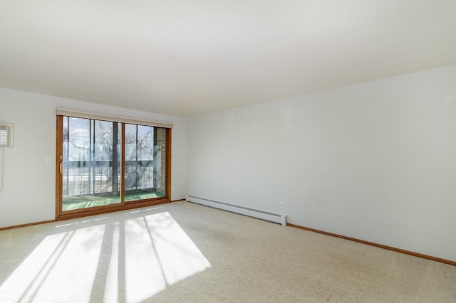 carpeted empty room featuring a baseboard heating unit