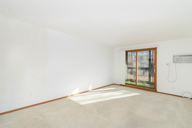 spare room featuring light carpet and an AC wall unit