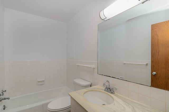 bathroom featuring vanity, toilet, a bathtub, and tile walls