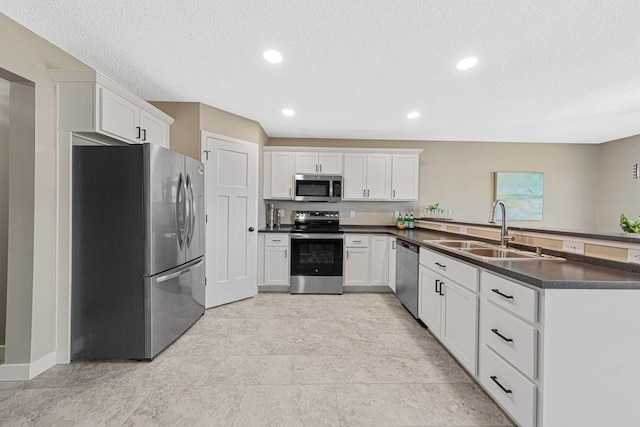 kitchen featuring kitchen peninsula, stainless steel appliances, white cabinetry, and sink