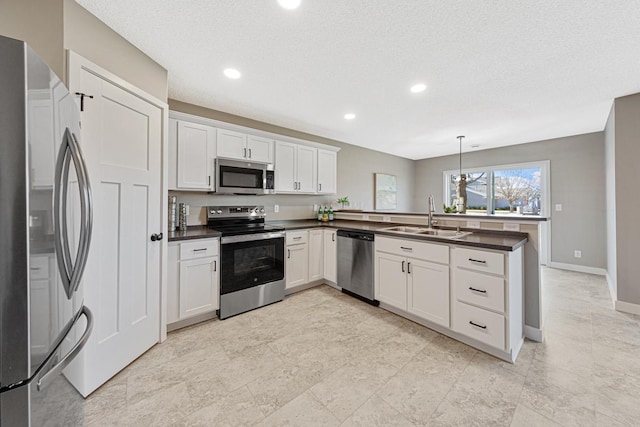 kitchen with white cabinets, stainless steel appliances, hanging light fixtures, and sink