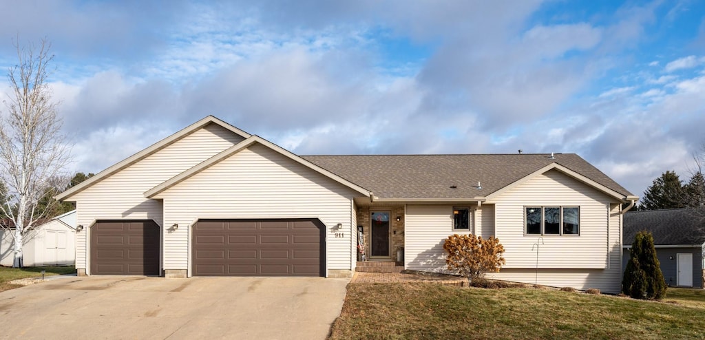 ranch-style house featuring a garage and a front lawn