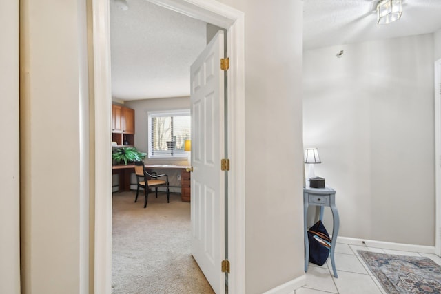 hall featuring light colored carpet and a baseboard heating unit