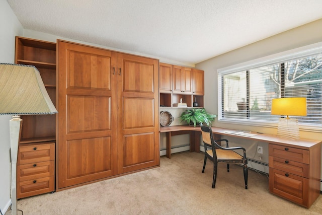 carpeted home office with a textured ceiling, built in desk, and baseboard heating