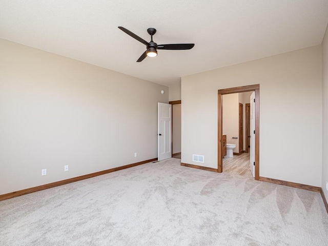 unfurnished bedroom featuring ensuite bath, ceiling fan, and light carpet