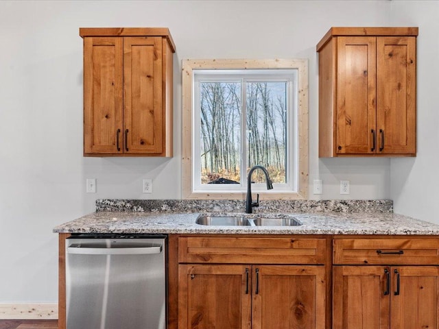 kitchen with dishwasher, light stone countertops, and sink