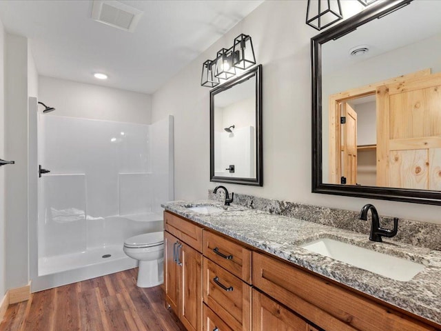 bathroom with vanity, hardwood / wood-style flooring, toilet, and walk in shower