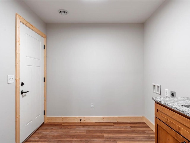 laundry area featuring cabinets, washer hookup, wood-type flooring, and electric dryer hookup