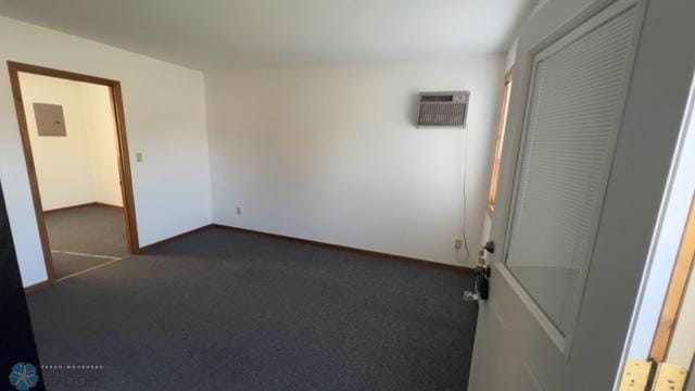 carpeted spare room with electric panel and a wall mounted AC