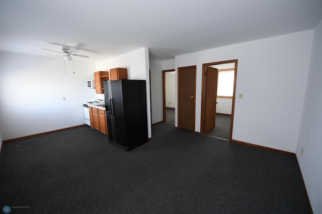 kitchen featuring dark colored carpet, ceiling fan, and white appliances