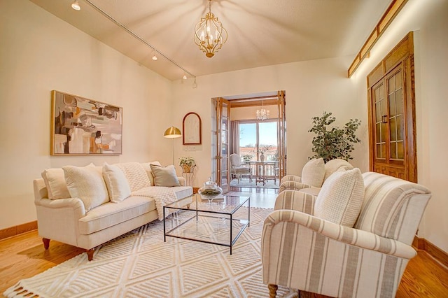 living room with a chandelier, hardwood / wood-style flooring, and track lighting