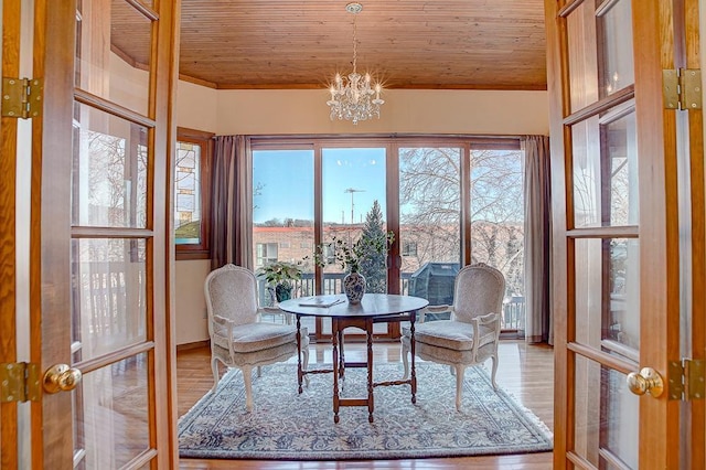 sunroom / solarium with french doors, wood ceiling, and an inviting chandelier