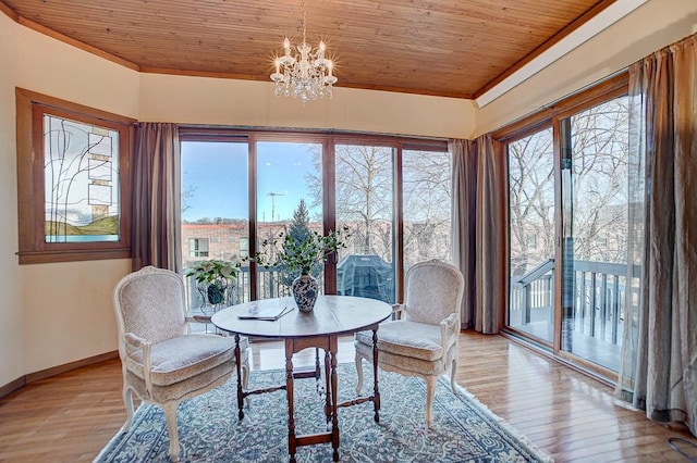 dining area featuring light wood-type flooring, an inviting chandelier, wooden ceiling, and crown molding