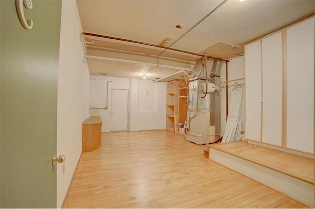 basement with heating unit and light hardwood / wood-style flooring