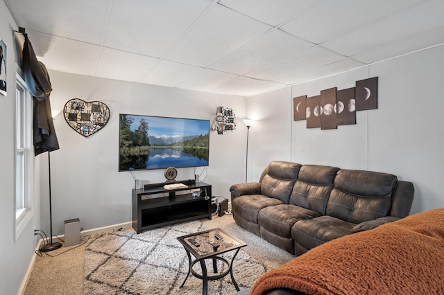 carpeted living room with a drop ceiling