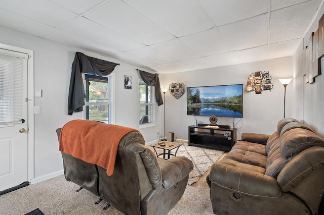 living room with a drop ceiling and light carpet