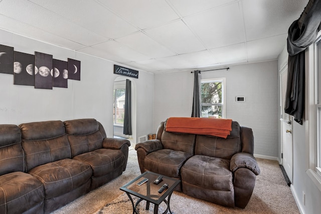 living room featuring a paneled ceiling and light carpet