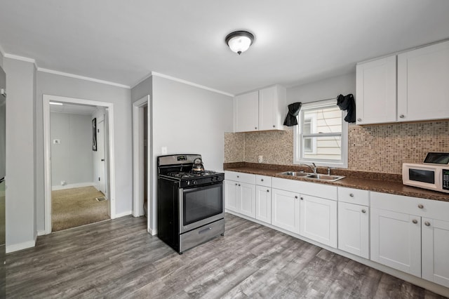 kitchen featuring white cabinets, light hardwood / wood-style floors, stainless steel gas range oven, and sink