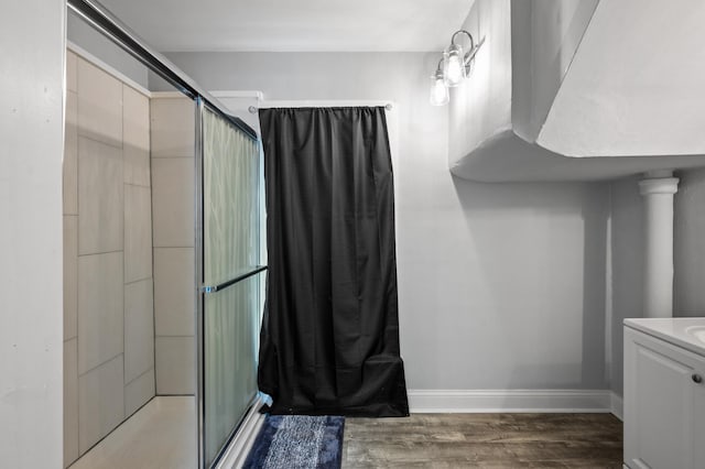 bathroom featuring hardwood / wood-style floors, vanity, and a shower with door