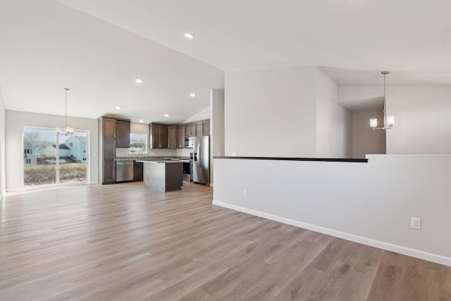 unfurnished living room with light hardwood / wood-style floors, lofted ceiling, and an inviting chandelier