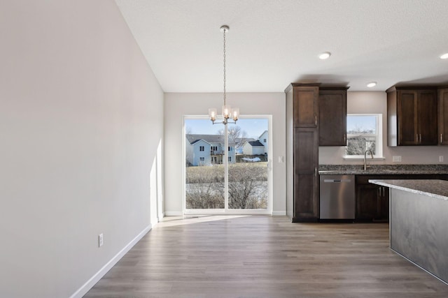 kitchen featuring dishwasher, hanging light fixtures, hardwood / wood-style flooring, a notable chandelier, and dark brown cabinets