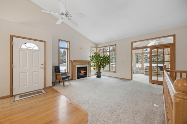 carpeted living room with ceiling fan, high vaulted ceiling, and a wealth of natural light