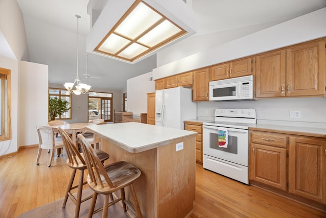 kitchen with white appliances, a center island, decorative light fixtures, a breakfast bar, and light wood-type flooring