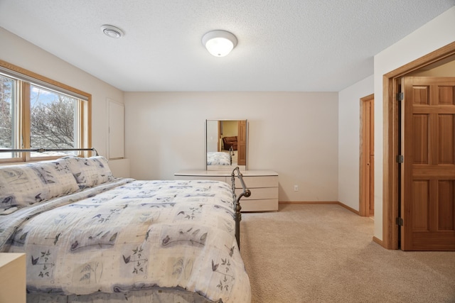 bedroom with a textured ceiling and light colored carpet