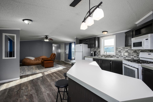 kitchen with dark wood-type flooring, decorative light fixtures, a center island, white appliances, and backsplash