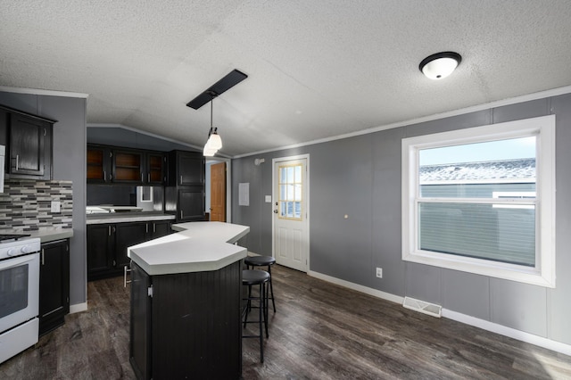 kitchen featuring a breakfast bar, pendant lighting, lofted ceiling, a center island, and white stove