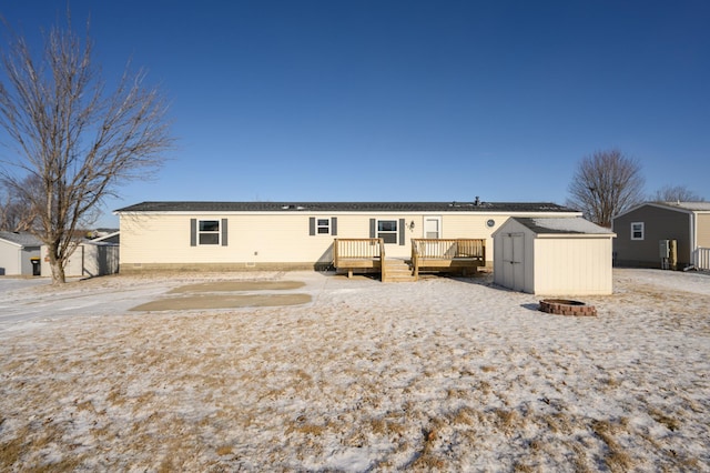 back of house with a wooden deck and a storage unit