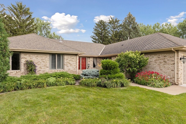 ranch-style home featuring a garage, a shingled roof, a front lawn, and brick siding