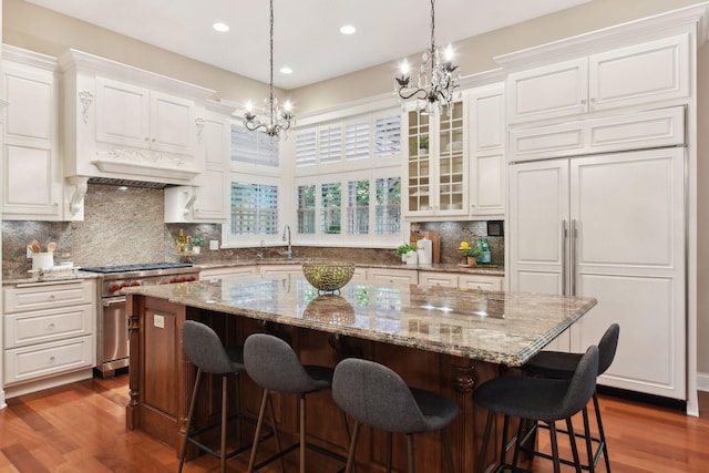 kitchen with white cabinetry, high end appliances, and a center island