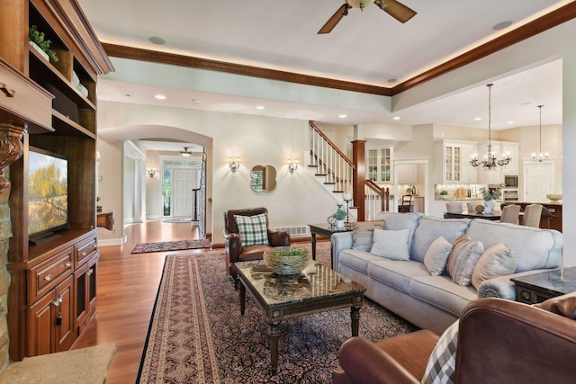 living room featuring light hardwood / wood-style floors and ceiling fan with notable chandelier