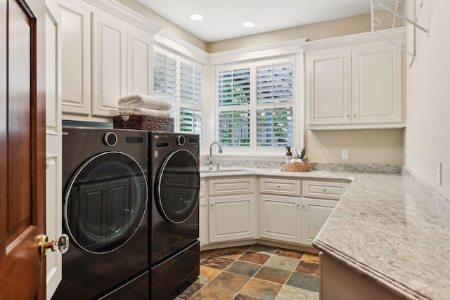 laundry room with washer and clothes dryer, sink, and cabinets