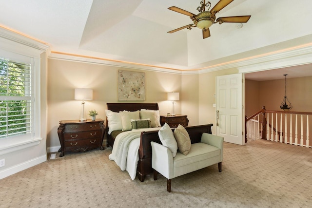 bedroom with ceiling fan, light colored carpet, crown molding, and a raised ceiling