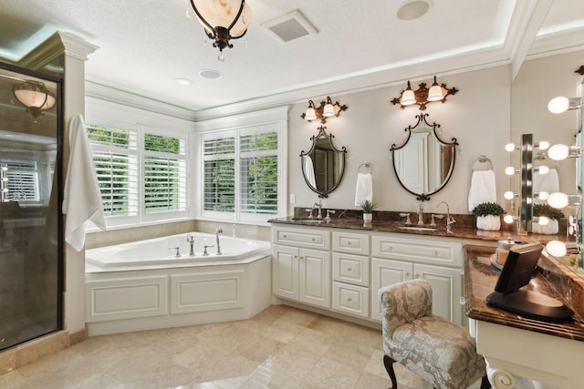 bathroom featuring a textured ceiling, vanity, ornamental molding, and separate shower and tub