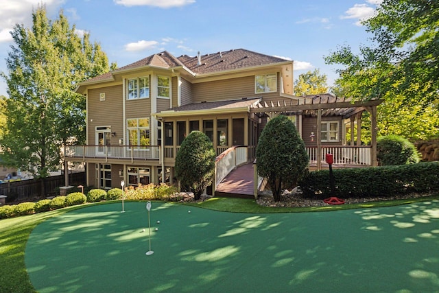 rear view of house featuring a pergola, a deck, and a sunroom