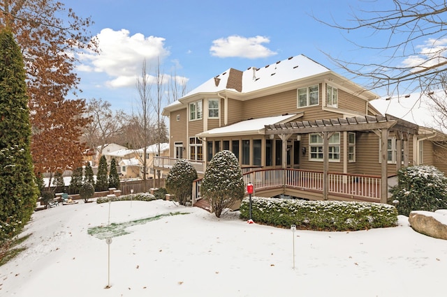 snow covered rear of property featuring a pergola and a sunroom