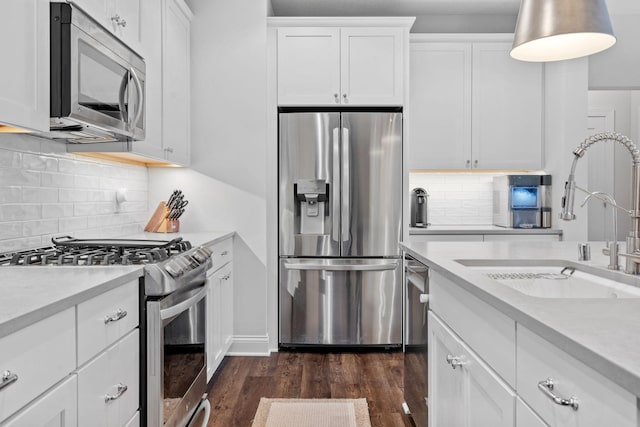 kitchen featuring white cabinets, decorative backsplash, stainless steel appliances, and sink