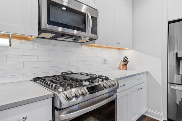 kitchen featuring white cabinets, decorative backsplash, and appliances with stainless steel finishes