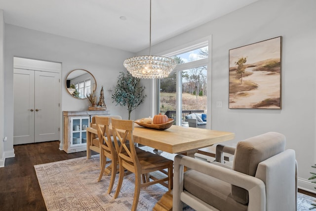 dining room with dark hardwood / wood-style floors and a notable chandelier