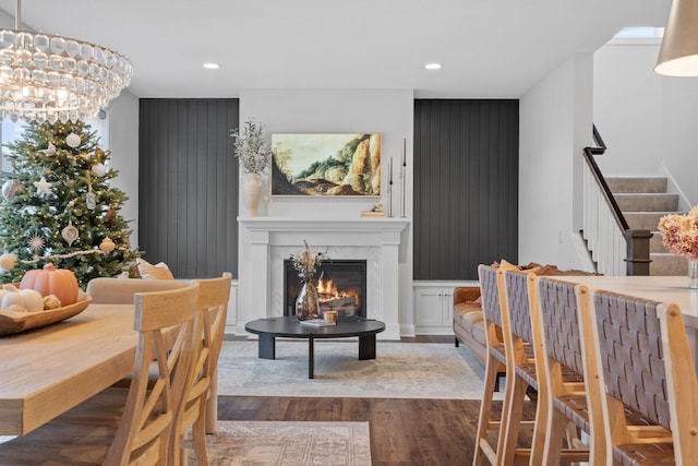 interior space with a premium fireplace, wood-type flooring, and an inviting chandelier