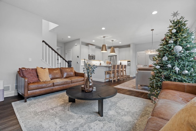 living room featuring dark hardwood / wood-style floors and an inviting chandelier