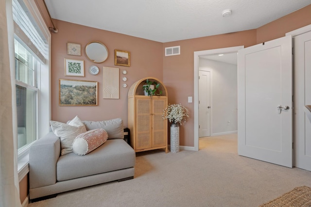 living area featuring light carpet