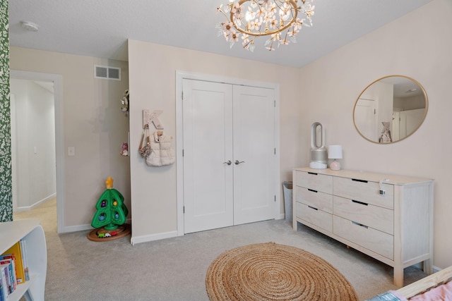 bedroom with a chandelier and light carpet