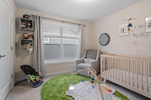 carpeted bedroom featuring a nursery area